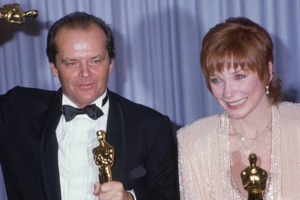 American actors Jack Nicholson and Shirley MacLaine pose together in front of a blue curtain, holding their Oscars for director James L Brooks` film,...