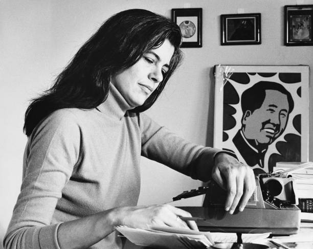 American author and cultural critic Susan Sontag works at her desk, circa 1971. Visible behind her is Roy Lichtenstein`s `Mao,` which appeared on the...