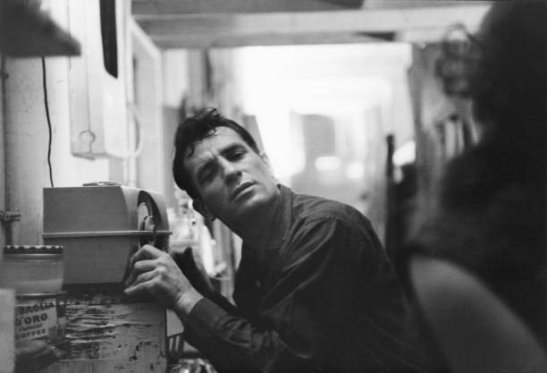American Beat writer Jack Kerouac leans closer to a radio to hear himself on a broadcast, 1959.