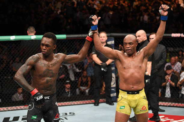 Anderson Silva of Brazil and Israel Adesanya of New Zealand react after the conclusion of their middleweight bout during the UFC 234 at Rod Laver...