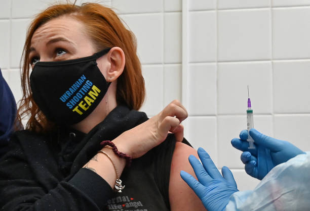 Anna Ilina, a member of the Ukrainian Olympic shooting team for the Tokyo 2020 Olympic Games, receives a dose of China's CoronaVac vaccine against...