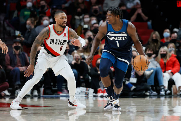 Anthony Edwards of the Minnesota Timberwolves moves the ball against the defense of Damian Lillard of the Portland Trail Blazers during the first...