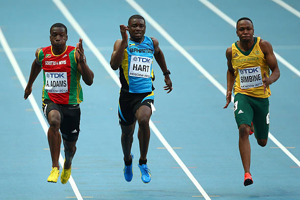 Antoine Adams of Saint Kitts and Nevis, Shavez Hart of Bahamas and Akani Simbine of South Africa compete in the Men's 100 metres heats during Day One...