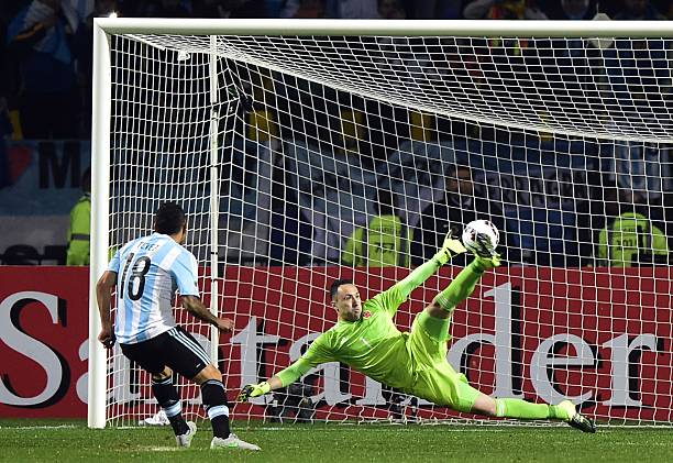 Argentina's forward Carlos Tevez scores the winning penalty kcik past Colombia's goalkeeper David Ospina during the 2015 Copa America football...