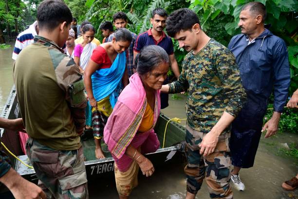 Army soldiers evacuate flood-affected villagers following heavy monsoon rainfalls in Rangia of Kamrup district, in India's Assam state on June 18,...