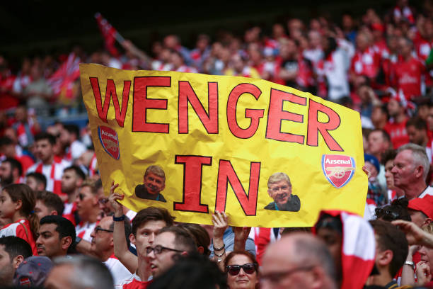 Arsenal fans hold up a sign that reads Wenger In during the Emirates FA Cup Final match between Arsenal and Chelsea at Wembley Stadium on May 27 2017...