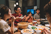 asian chinese family and cousins having reunion dinner at home