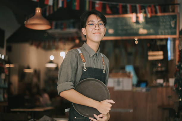 asian chinese teenage boy waiter looking at camera smiling work at picture