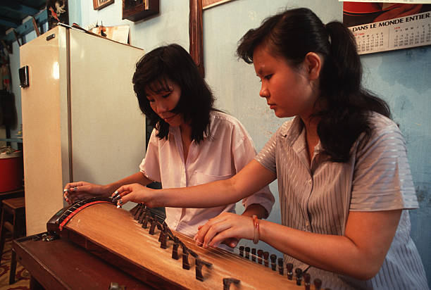At home with the Luong family Luong Trang teaches a girl how to play music on a traditional Vietnamese Instruments called a Dan Tranh She gives music...