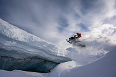 Athlete doing a step up jump on a snowmobile