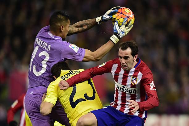 Atletico Madrid's Uruguayan defender Diego Godin vies with Villarreal's French goalkeeper Alphonse Areola during the Spanish league football match...