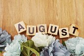 august alphabet letter wooden cube with space copy on wooden background and flower decoration