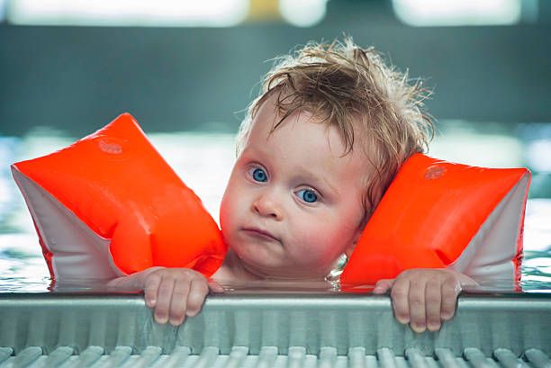 Baby boy makes face in a swiming pool