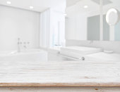 Background of blurred bathroom interior with wooden table in front