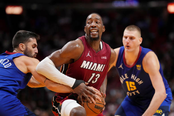 Bam Adebayo of the Miami Heat fights for control of the ball against Facundo Campazzo and Nikola Jokic of the Denver Nuggets during the second half...