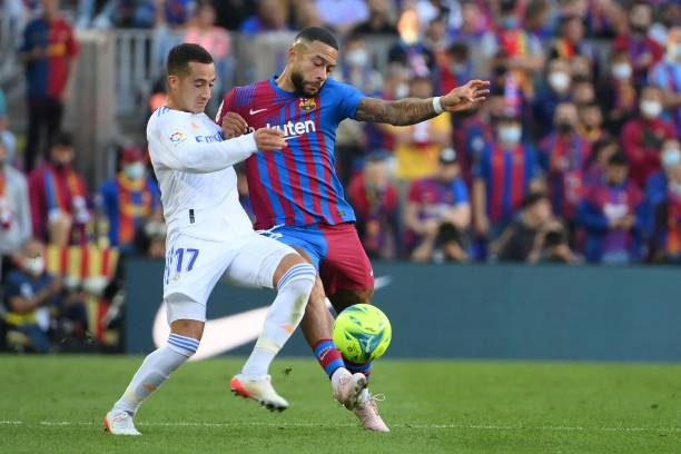 Barcelona's Dutch forward Memphis Depay vies with Real Madrid's Spanish forward Lucas Vazquez during the Spanish League football match between FC...