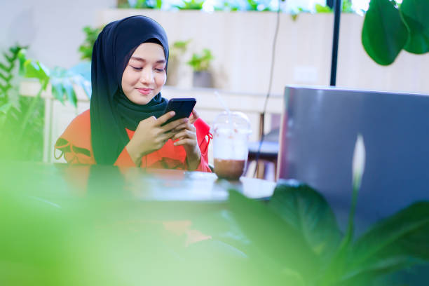 Beautiful happy muslim woman using smartphone
