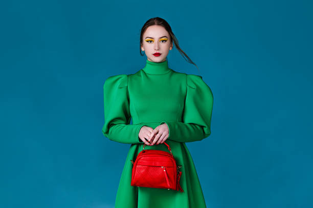 beautiful woman in green dress holding a red handbag picture