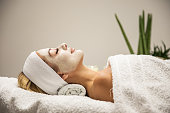 Beautiful woman with mask on face in spa beauty salon
