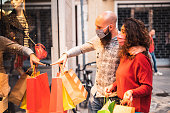 Beautiful young couple enjoying in shopping, having fun together, with the face mask