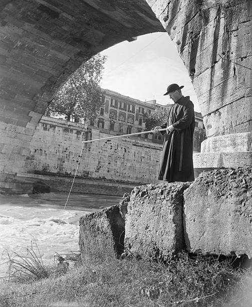 Beneath the Arch of an ancient Roman bridge, a patient priest casts a line into the Tiber on a sunny fall afternoon, hoping to catch a fish. The...
