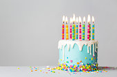 Birthday cake with drip icing and colorful candles