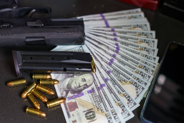 black gun on american dollars background. - comercio de armas fotografías e imágenes de stock