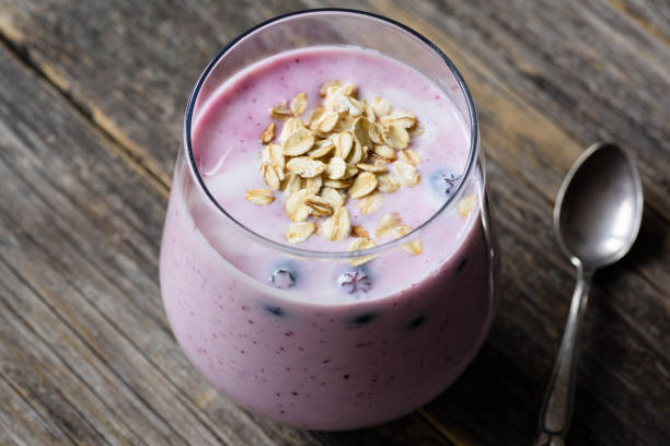 Blueberry smoothie with oats in glass on wooden table