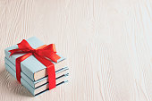 Books tied with ribbon on a wooden background with copy space: concept of donating books
