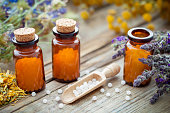 Bottles of homeopathic globules and healing herbs. Homeopathy concept.