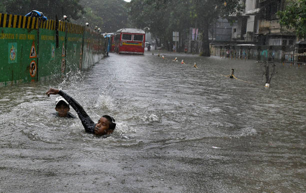 Boys are swimming in the flooded street amidst heavy rain in Mumbai. Mumbai experienced flooded streets in low-lying areas, and traffic was...