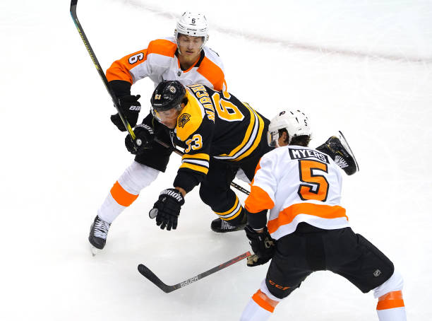 Brad Marchand of the Boston Bruins is caught between Philippe Myers and Travis Sanheim of the Philadelphia Flyers in the first period during Game One...