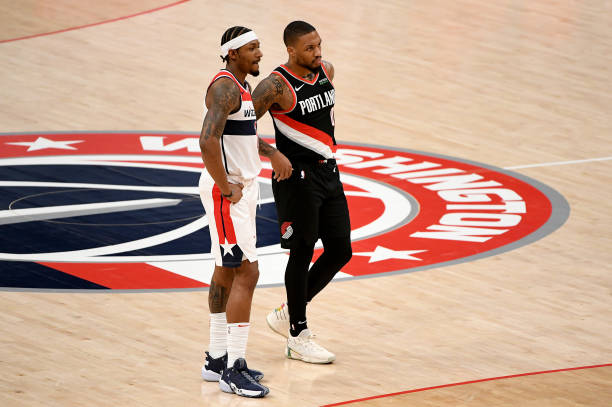 Bradley Beal of the Washington Wizards and Damian Lillard of the Portland Trail Blazers look on during the first half at Capital One Arena on...