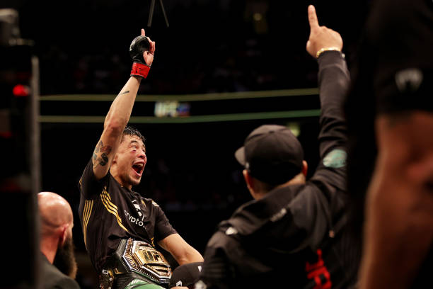 Brandon Moreno of Mexico celebrates with the flyweight interim title belt after knocking out Kai Kara France of New Zealand in the third round during...