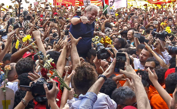 Brazilian expresident Luiz Inacio Lula da Silva waves to supporters after attending a Catholic Mass in memory of his late wife Marisa Leticia at the...