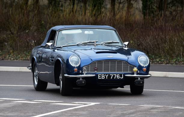 Britain's Prince Charles Prince of Wales drives his Aston Martin DB6 as he arrives for a visit to the new Aston Martin Lagonda factory in Barry Wales...
