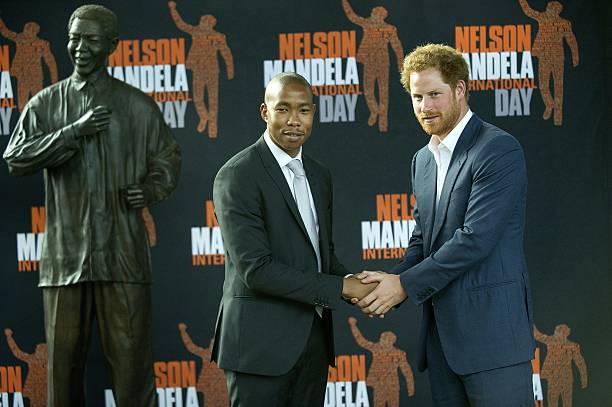 britains-prince-harry-shakes-hands-with-mbuso-mandela-grandson-of-the-picture-id499787598