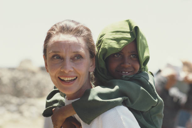 British actress and humanitarian Audrey Hepburn carrying an Ethiopian girl on her back while on her first field mission for UNICEF in Ethiopia,...