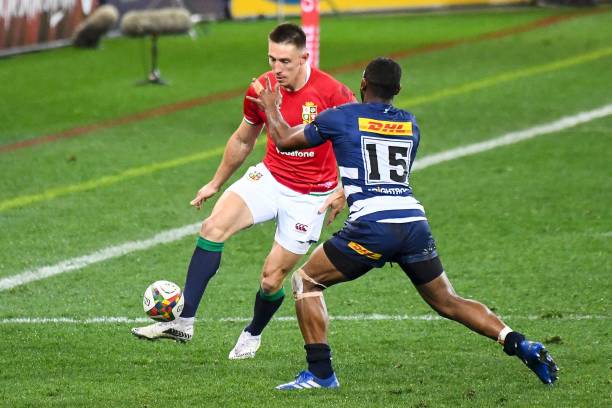 British and Irish Lions' wing Josh Adams (L) kicks the ball past Stormers full-back Sergeal Petersen during the rugby union tour match between Stormers and the British and Irish Lions at The Cape Town Stadium in Cape Town on July 17, 2021. (Photo by RODGER BOSCH / AFP) (Photo by RODGER BOSCH/AFP via Getty Images)