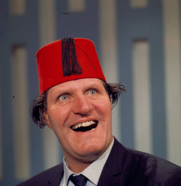 british-comedian-and-magician-tommy-cooper-posed-wearing-his-red-fez-picture-id495788315