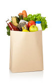 Brown paper shopping bag full of groceries on white backdrop