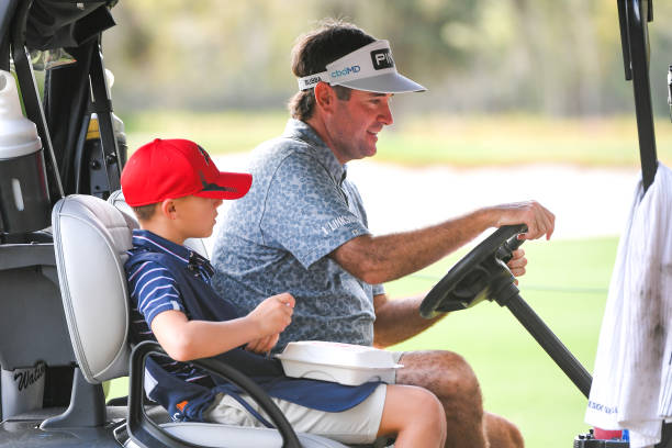 Bubba Watson and his son Caleb Watson ride in a golf cart together during the PGA TOUR Champions Thursday Pro-am at PNC Championship at Ritz-Carlton...