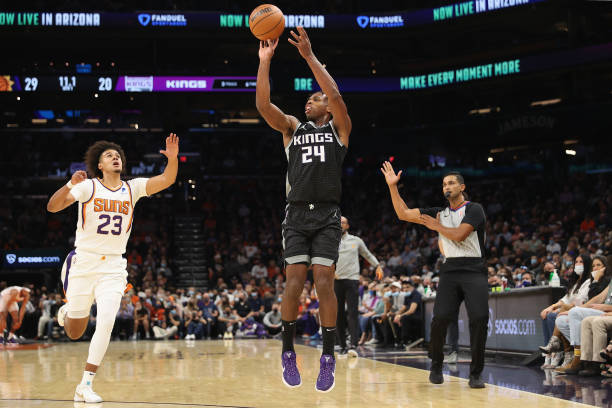 Buddy Hield of the Sacramento Kings puts up a three-point shot over Cameron Johnson of the Phoenix Suns during the first half of the NBA game at...