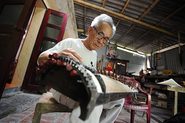 Bui Van Vuoc makes final inspection on a dan thap luc instrument at his workshop in Vinh Bao on September 19 2015 in Hai Phong Vietnam 81yearsold Bui...