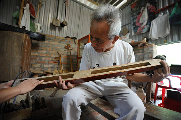 Bui Van Vuoc makes final inspection on dan bau instrument at his workshop in Vinh Bao on September 19 2015 in Hai Phong Vietnam 81yearsold Bui Van...