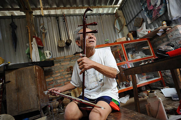Bui Van Vuoc plays a dan nhi instrument at his workshop in Vinh Bao on September 19 2015 in Hai Phong Vietnam 81yearsold Bui Van Vuoc of Bao Ha Dong...