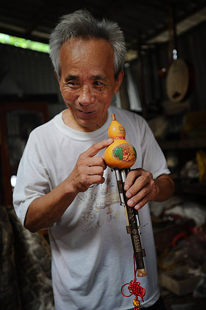 Bui Van Vuoc shows a sao bau instrument at his workshop in Vinh Bao on September 19 2015 in Hai Phong Vietnam 81yearsold Bui Van Vuoc of Bao Ha Dong...