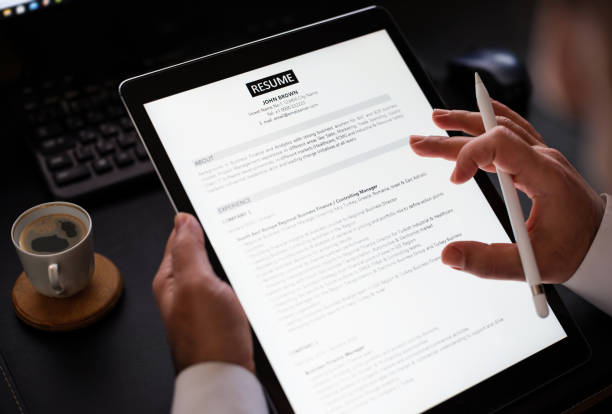 businessman reading a resume on digital tablet to hire correct personnel - cv has novel stock pictures, royalty-free photos & images