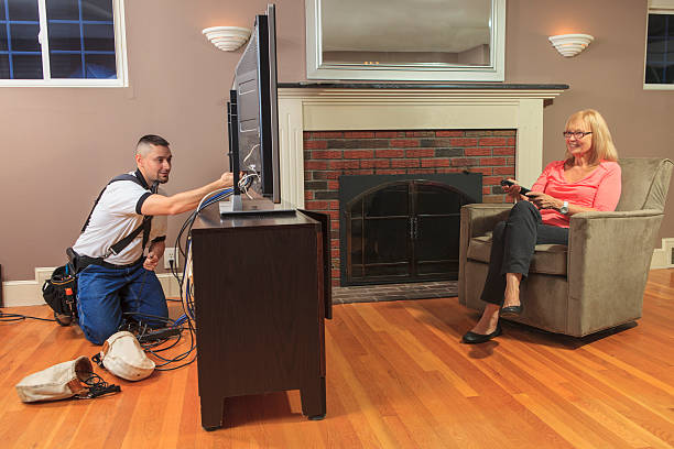cable installer working in a home behind the tv - tv repair man stock pictures, royalty-free photos & images