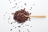 Cacao nibs on wood spoon, white background